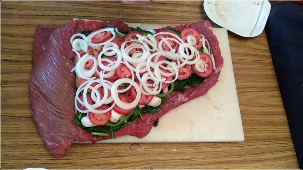 rellenando la ternera con pimiento, tomate y cebolla